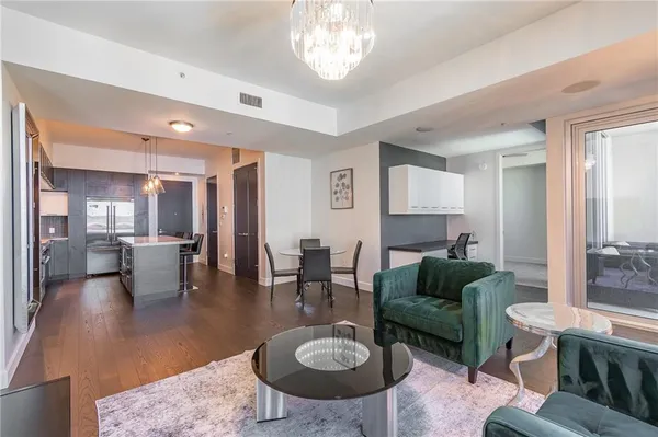 a living room with couches a table and chairs with a dining table