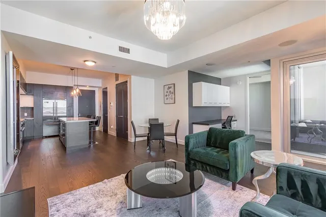 a living room with couches a table and chairs with a dining table