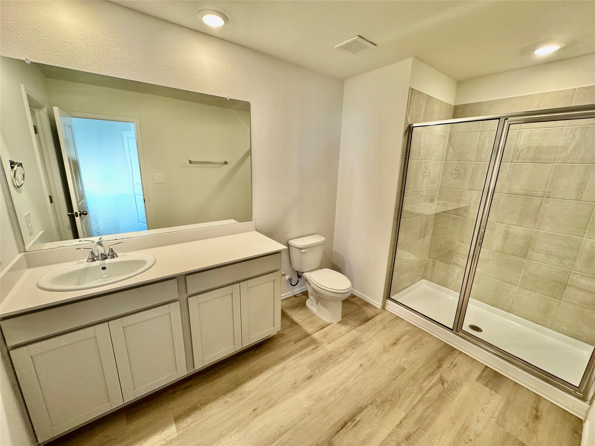 105 Calcite Road, Unit 4 Kyle, TX 78640 - Photo 3 of 7 Full bathroom with a shower stall, vanity, and light wood-style floors