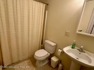 a bathroom with a toilet a sink and a mirror
