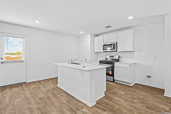 a kitchen with granite countertop a sink and a stove top oven