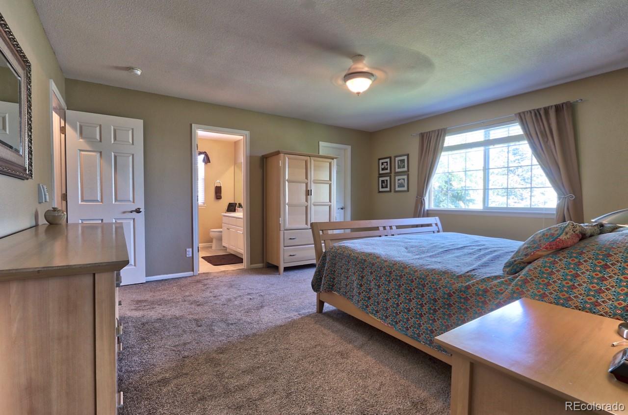 9818 Mulberry Way Highlands Ranch, CO 80129 - Photo 18 of 34 a spacious bedroom with a bed and a dresser in it