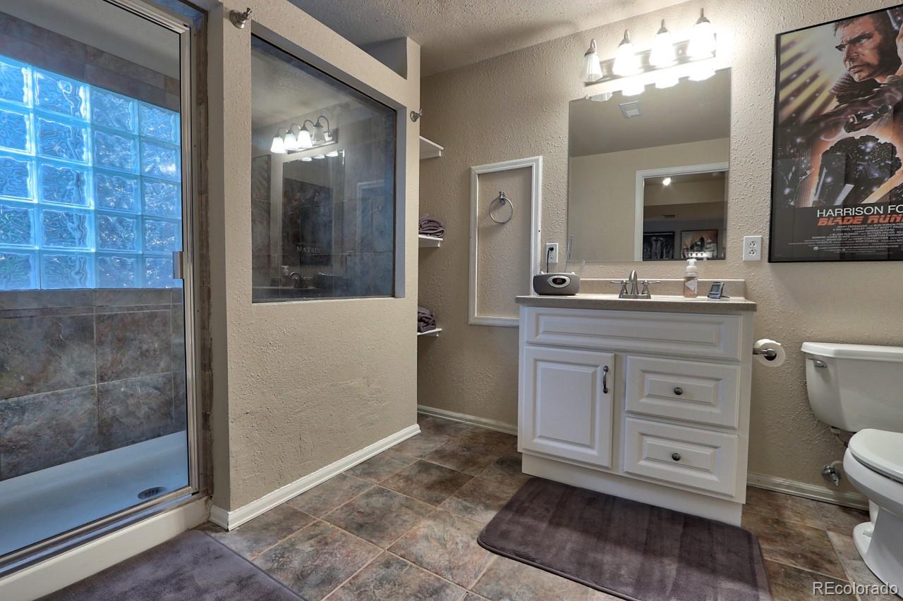 9818 Mulberry Way Highlands Ranch, CO 80129 - Photo 25 of 34 a bathroom with a granite countertop sink a toilet and a mirror