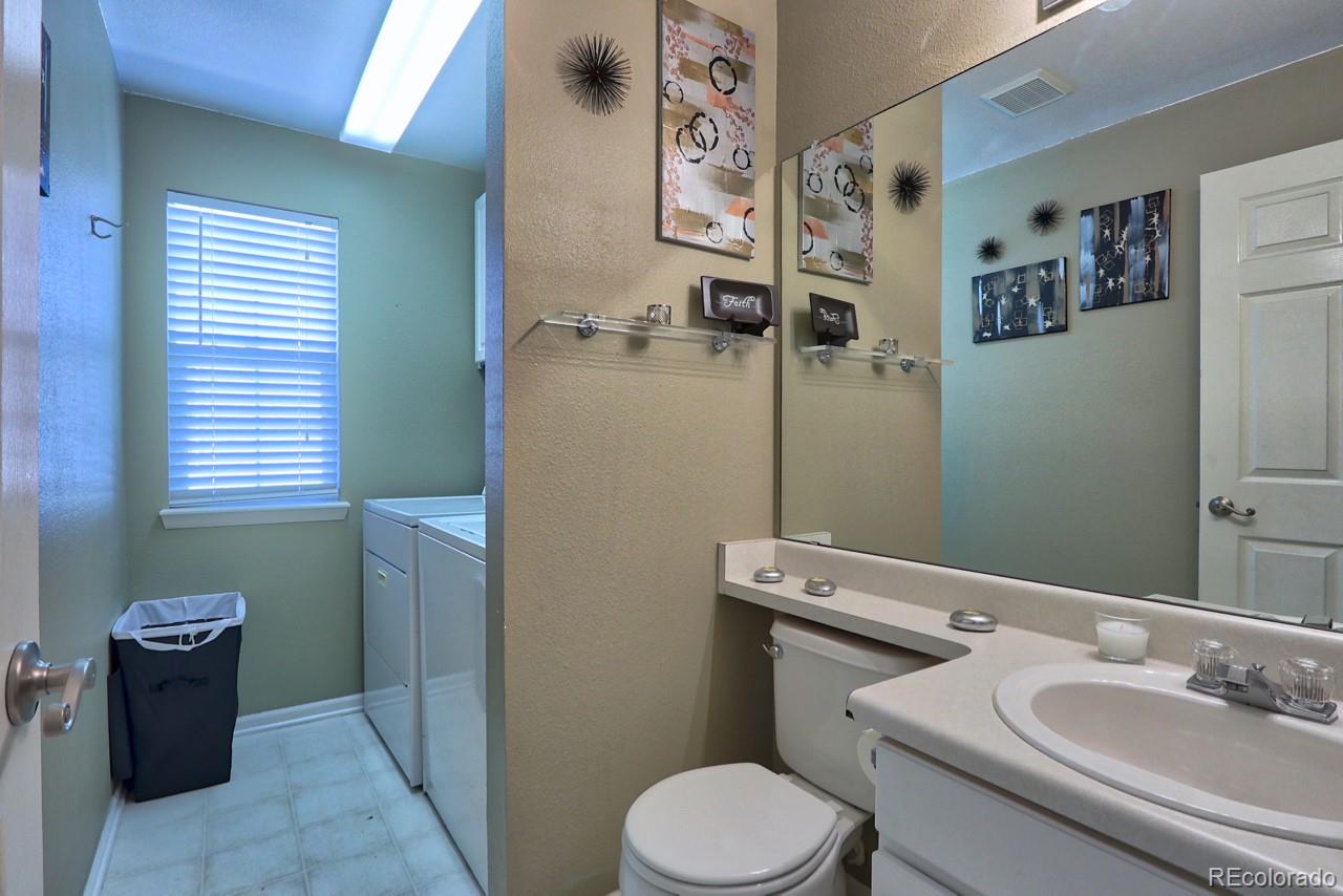 9818 Mulberry Way Highlands Ranch, CO 80129 - Photo 32 of 34 a bathroom with a toilet sink and mirror