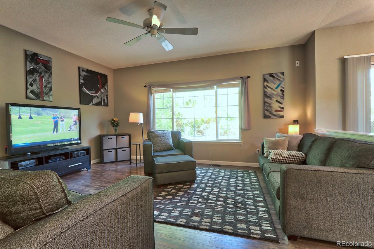 9818 Mulberry Way Highlands Ranch, CO 80129 - Photo 6 of 34 a living room with furniture and a flat screen tv