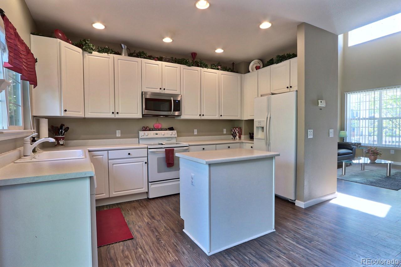 9818 Mulberry Way Highlands Ranch, CO 80129 - Photo 10 of 34 a kitchen with kitchen island granite countertop a sink cabinets and wooden floor