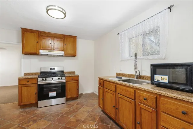 a kitchen with stainless steel appliances granite countertop a stove a sink and a microwave