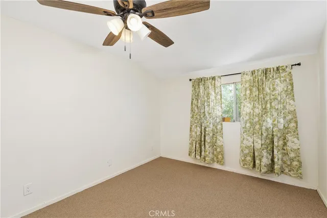 an empty room with a fan and a fan