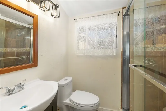 a bathroom with a toilet a sink and shower