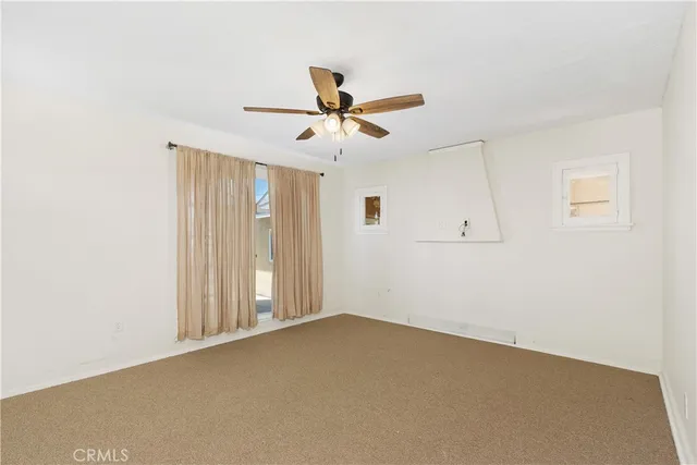 an empty room with chandelier fan