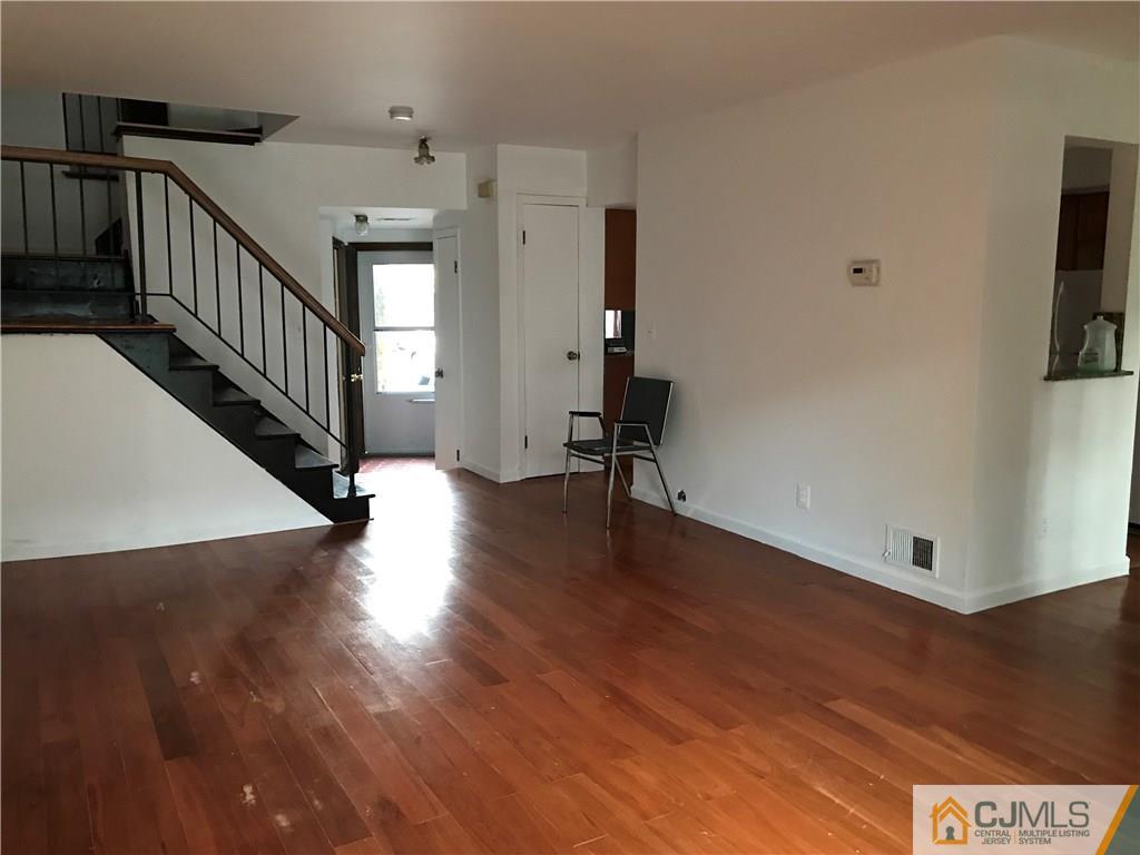 5807 Hana Road Edison, NJ 08817 - Photo 3 of 8 a view of a hallway with wooden floor and stairs