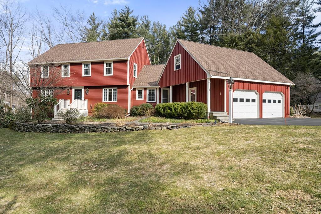a view of a big yard in front of a brick house with large windows