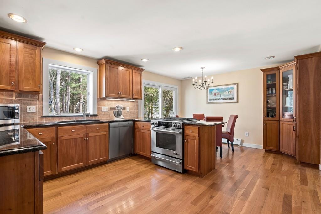 14 Ridge Hill Road Sudbury, MA 01776 - Photo 13 of 34 a kitchen with stainless steel appliances granite countertop wooden floors and white cabinets