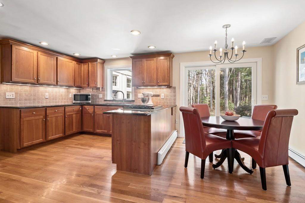 14 Ridge Hill Road Sudbury, MA 01776 - Photo 15 of 34 a kitchen with stainless steel appliances granite countertop a sink a stove a dining table and chairs
