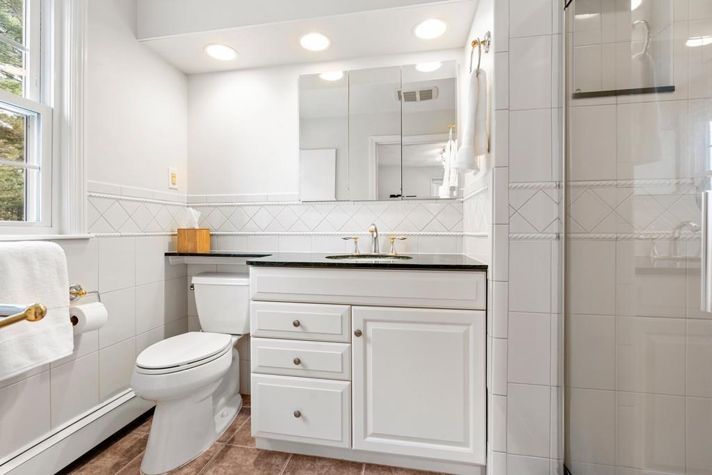 14 Ridge Hill Road Sudbury, MA 01776 - Photo 22 of 34 a bathroom with a granite countertop sink a toilet and a mirror