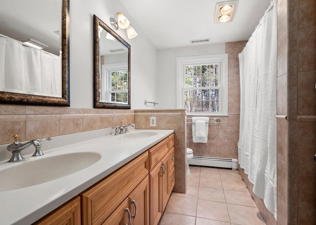 14 Ridge Hill Road Sudbury, MA 01776 - Photo 25 of 34 a bathroom with a double vanity sink a mirror and a bathtub