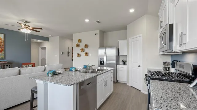 a kitchen with stainless steel appliances granite countertop a stove and a microwave