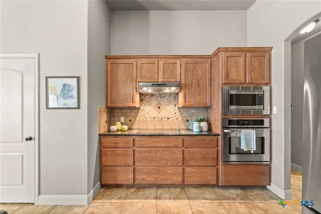 a kitchen with stainless steel appliances granite countertop a refrigerator and a stove