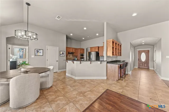 a living room with kitchen island furniture and a chandelier