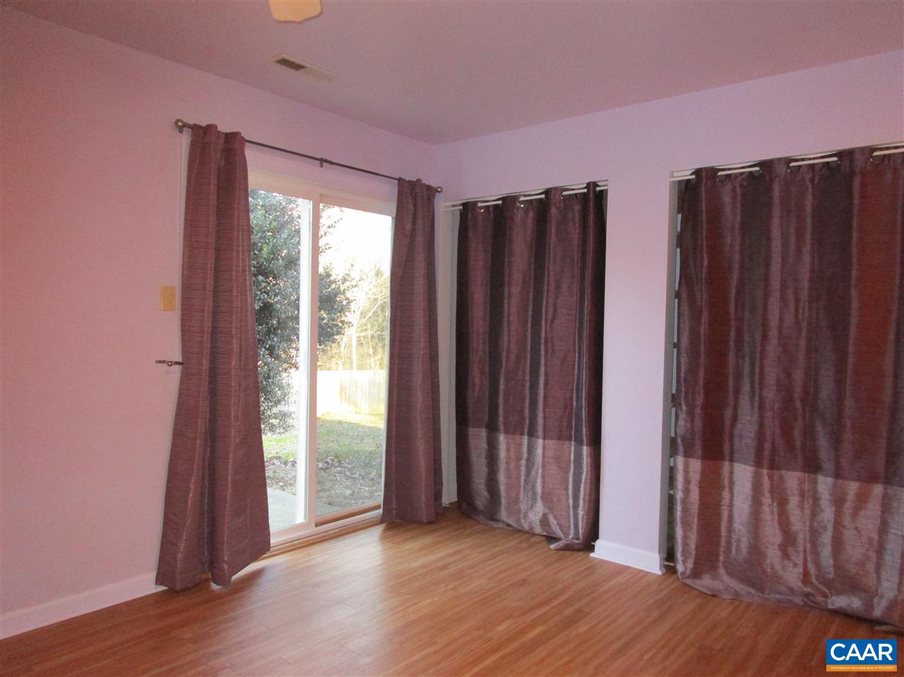 699 Carnation Road Ruckersville, VA 22968 - Photo 14 of 40 an empty room with wooden floor and windows with curtains