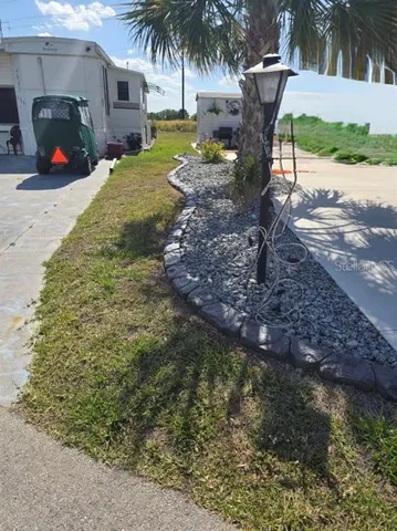 a view of a backyard with a table and chairs under a large tree
