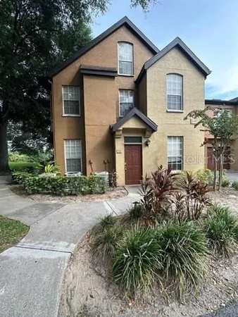 a front view of a house with a yard and potted plants