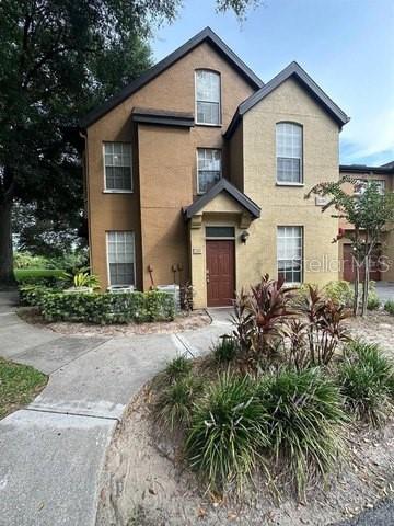 a front view of a house with a yard and potted plants