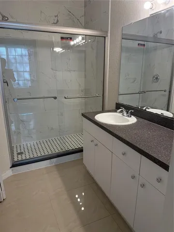 a bathroom with a sink a mirror and shower