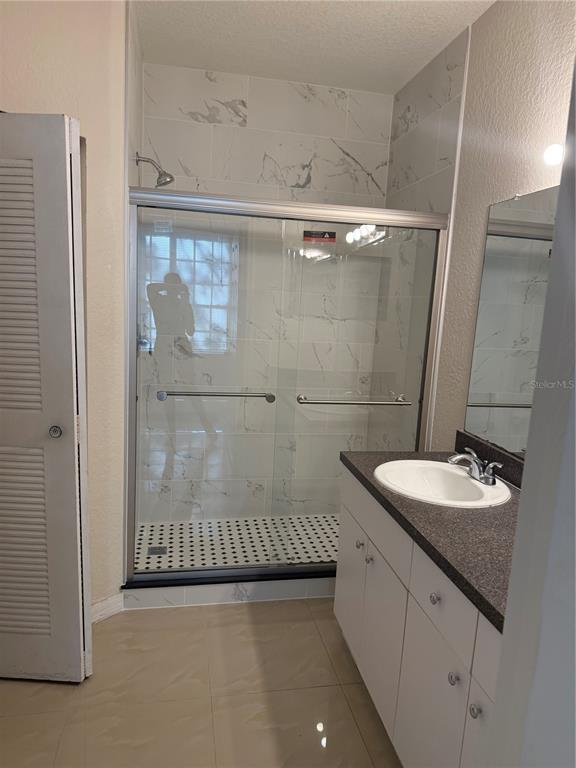 6368 Raleigh Street, Unit 1803 Orlando, FL 32835 - Photo 14 of 14 a bathroom with a sink a mirror and shower