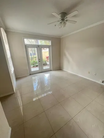 an empty room with windows and ceiling fan