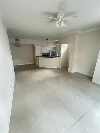 an empty room with a ceiling fan and entryway