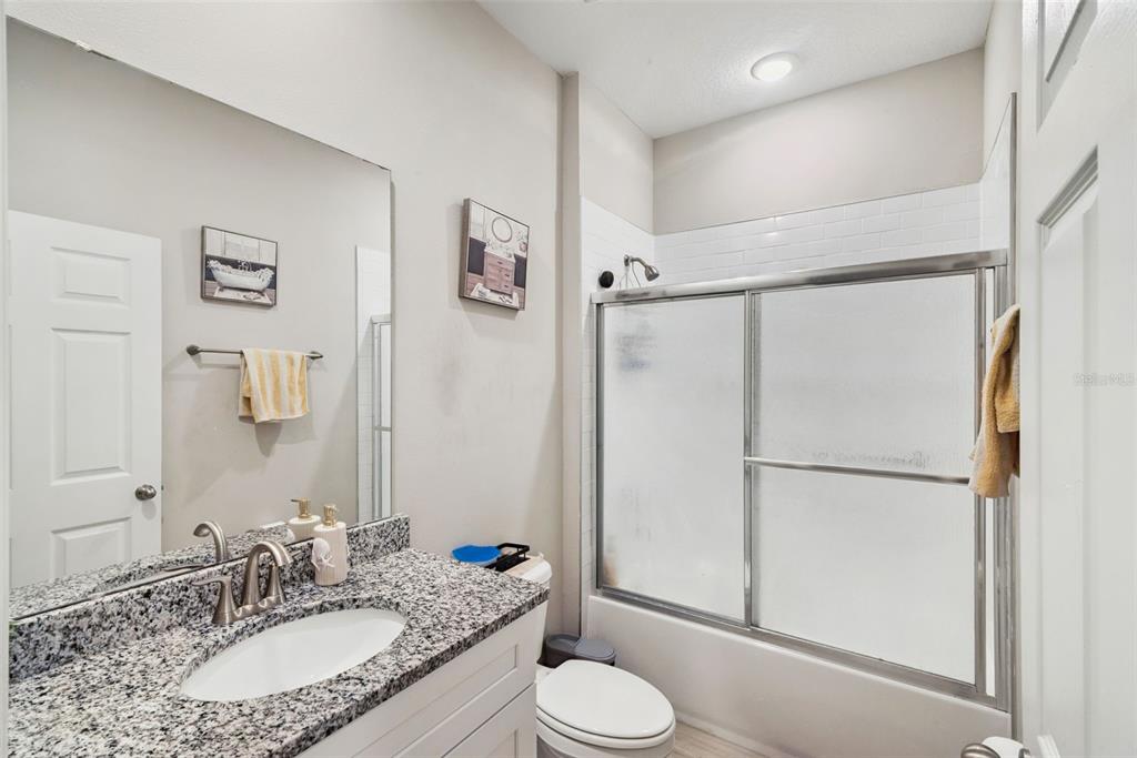 1021 Titcomb Street Eustis, FL 32726 - Photo 11 of 40 a bathroom with a granite countertop sink toilet and shower