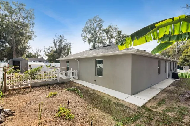 a view of a house with a small yard and wooden fence