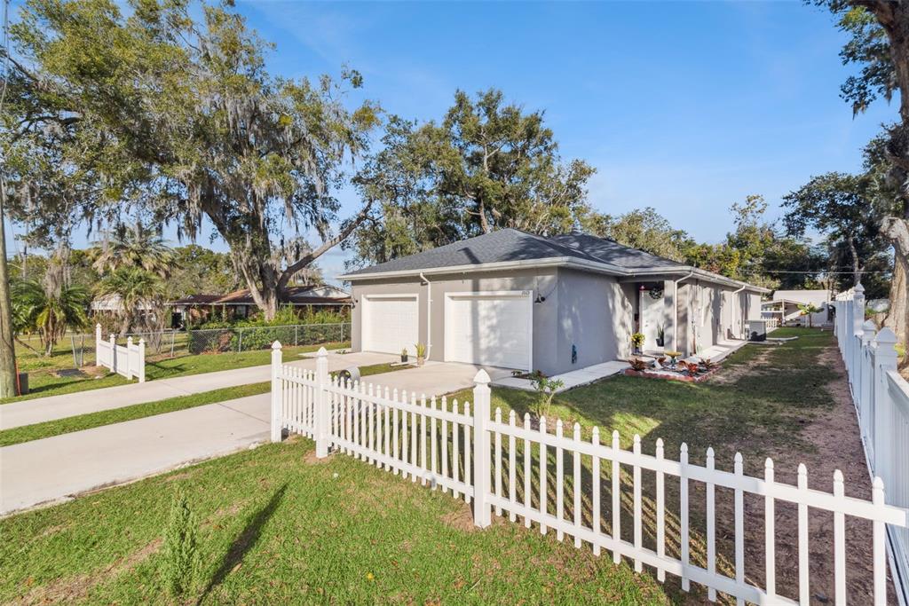 1021 Titcomb Street Eustis, FL 32726 - Photo 17 of 40 a view of a house with a small yard and wooden fence