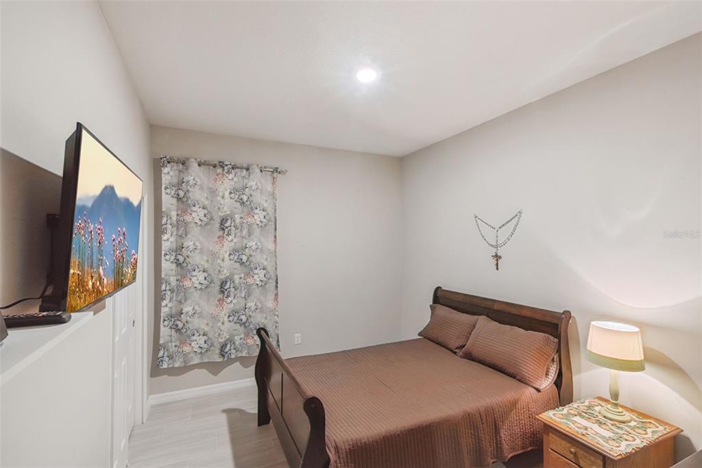 1021 Titcomb Street Eustis, FL 32726 - Photo 30 of 40 a bedroom with a bed and a flat screen tv