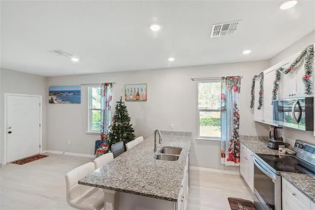 a kitchen with stainless steel appliances granite countertop a sink stove and cabinets