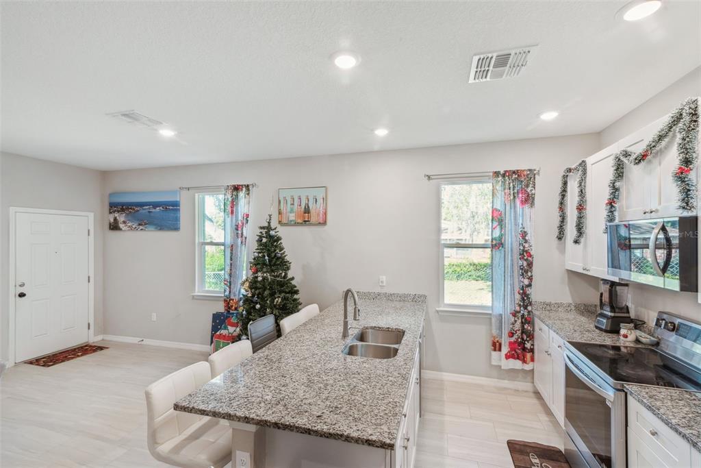 1021 Titcomb Street Eustis, FL 32726 - Photo 8 of 40 a kitchen with stainless steel appliances granite countertop a sink stove and cabinets