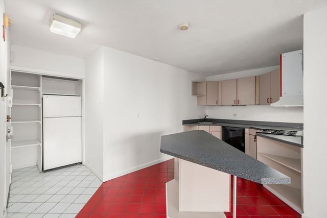 a kitchen with granite countertop a stove and a refrigerator