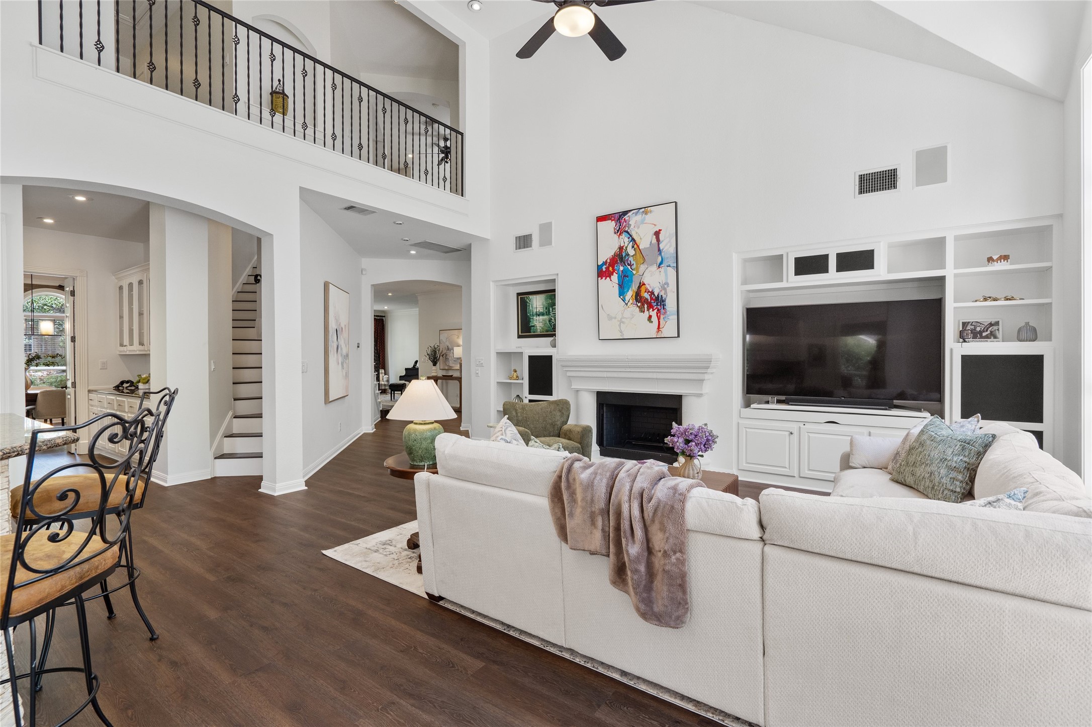 4313 Rio Robles Drive Austin, TX 78746 - Photo 7 of 40 A spacious living area with soaring ceilings features rich wood flooring and a classic fireplace, perfect for gathering.