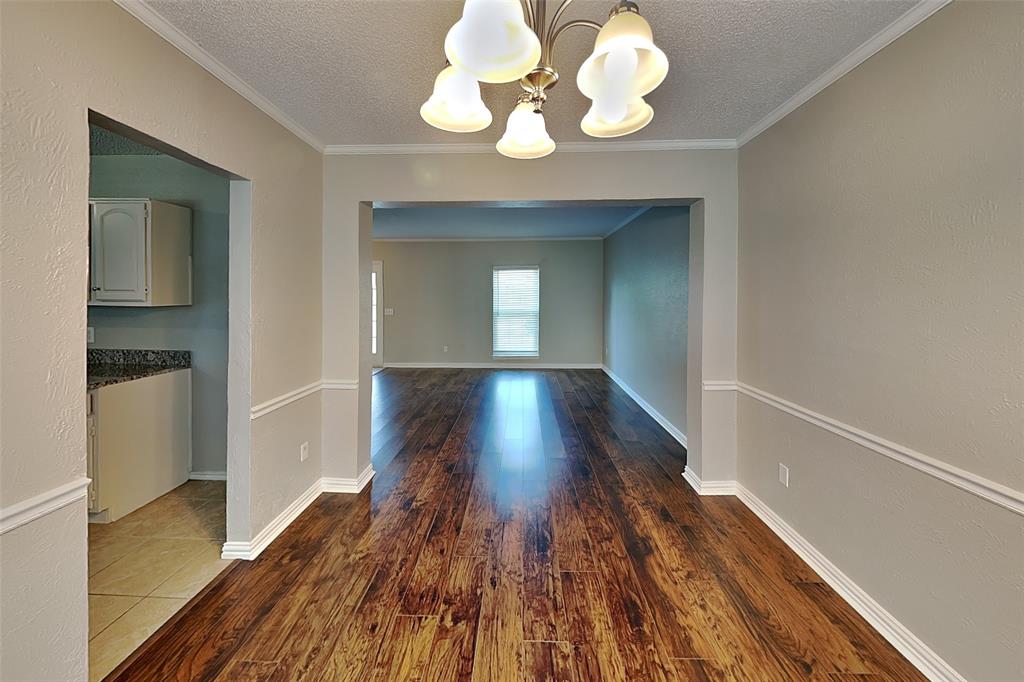604 Ashby Place Allen, TX 75002 - Photo 18 of 21 a view of a hallway with wooden floor and a chandelier