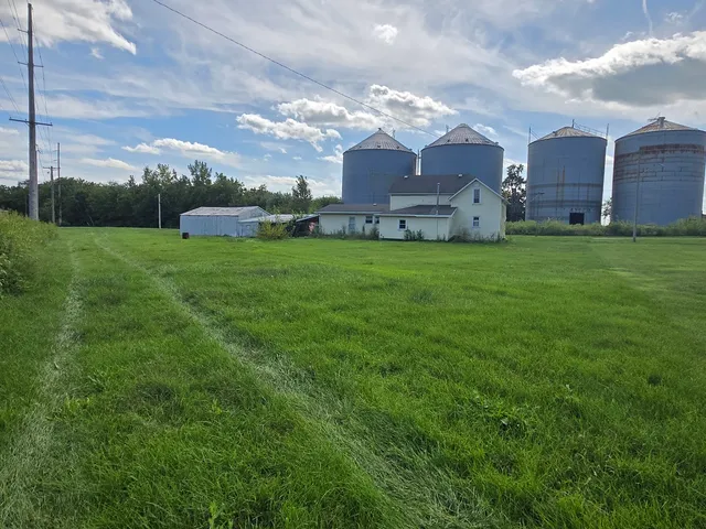 a view of a house with a big yard and large trees