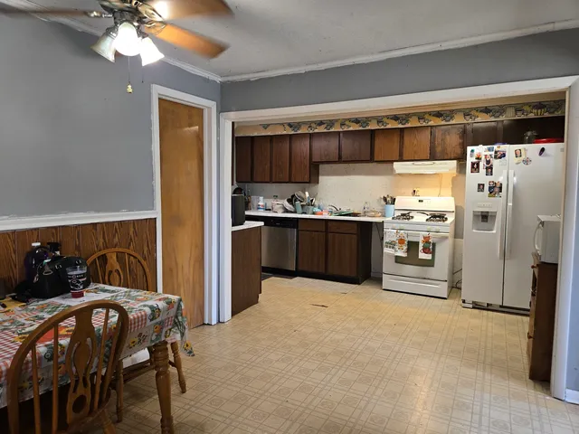 a kitchen with stainless steel appliances kitchen island granite countertop a refrigerator and a stove top oven