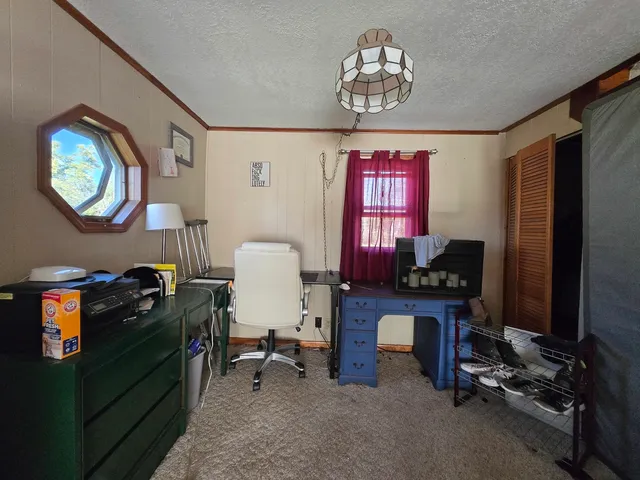 a view of a workspace with furniture and a window