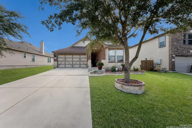 a front view of a house with a yard and tree