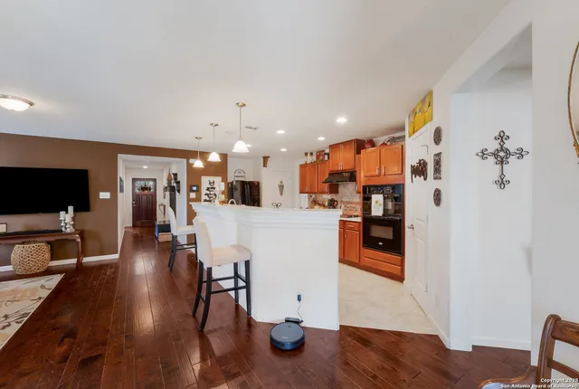 a view of a living room and kitchen with furniture wooden floor and windows