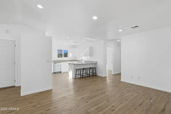 a view of an empty room with wooden floor
