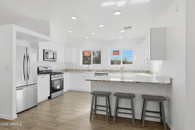 a kitchen with stainless steel appliances granite countertop a sink stove and refrigerator