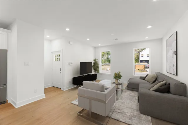 a living room with furniture and wooden floor