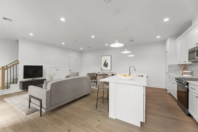 a living room with stainless steel appliances furniture and a view of kitchen