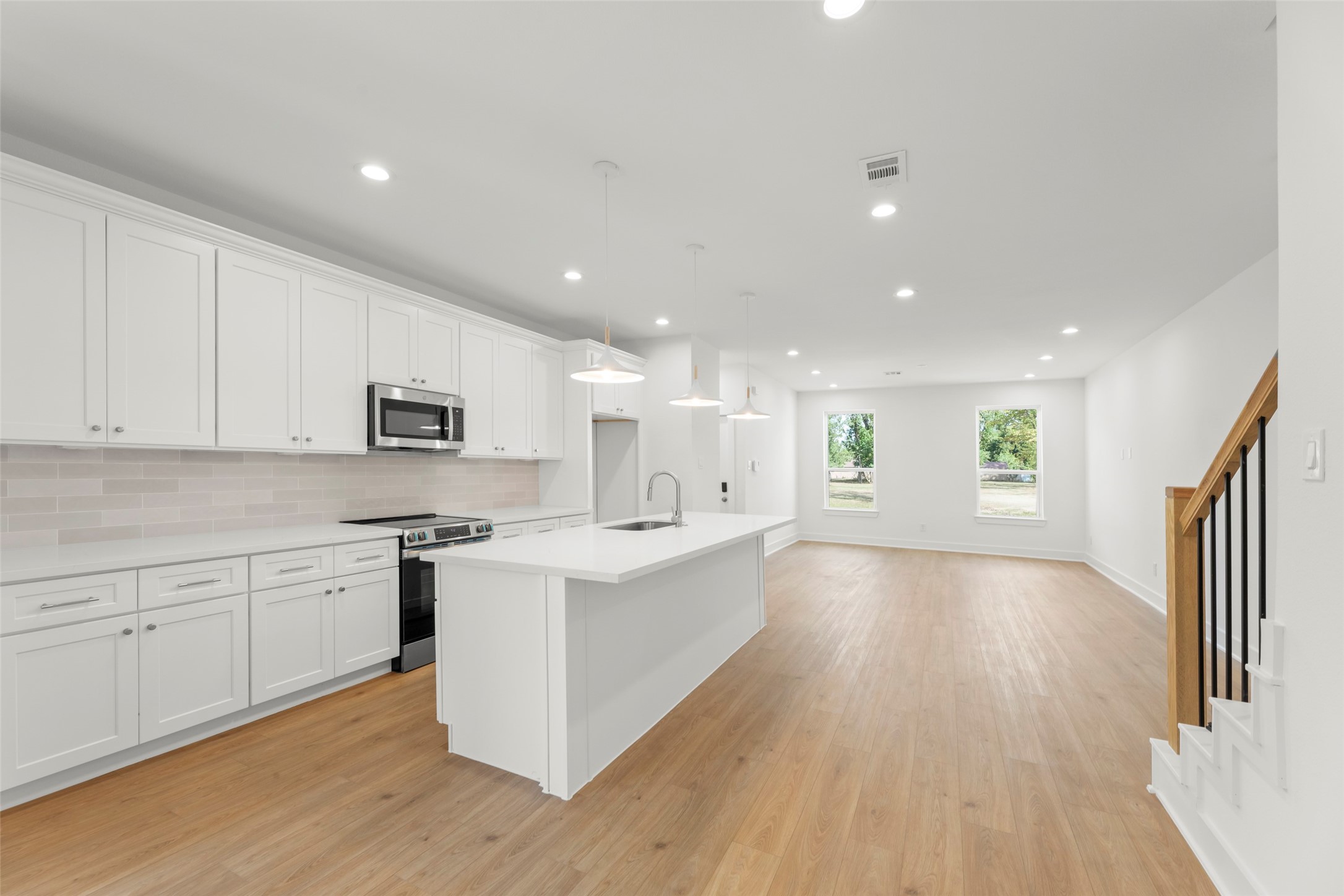 1477 Ferguson Way Houston, TX 77088 - Photo 22 of 37 a large kitchen with stainless steel appliances a large counter top a sink a refrigerator and white cabinets